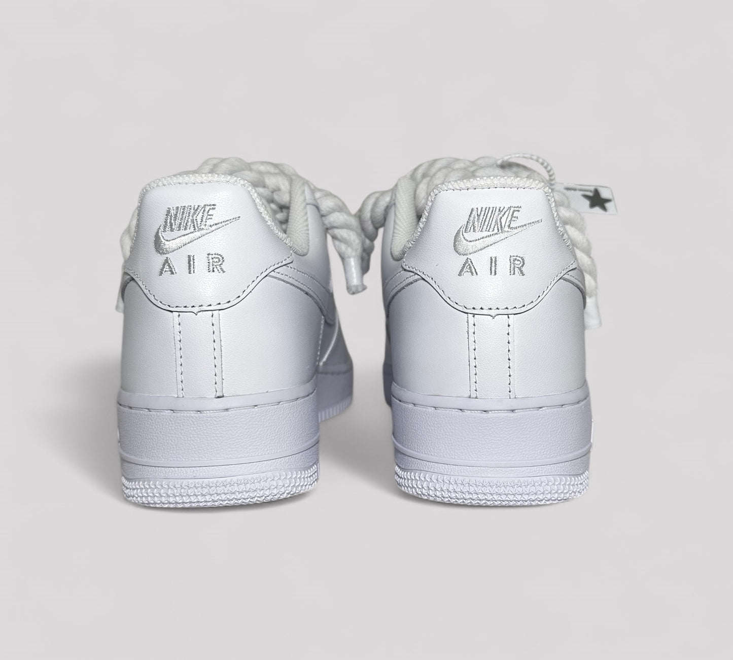 White Nike Air Force sneakers on a light gray background