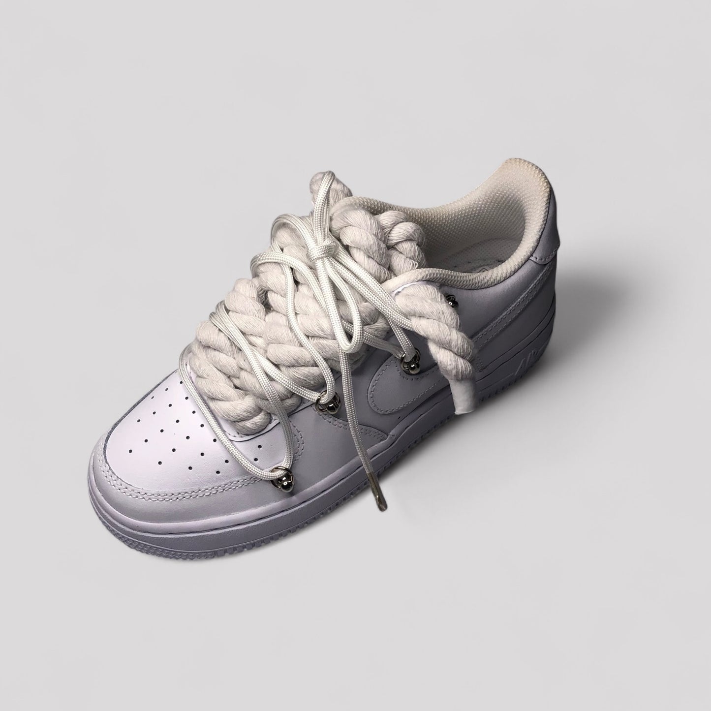 Gray sneaker with white laces on a light gray background