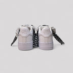 Pair of white sneakers with black and gray accents on a light gray background
