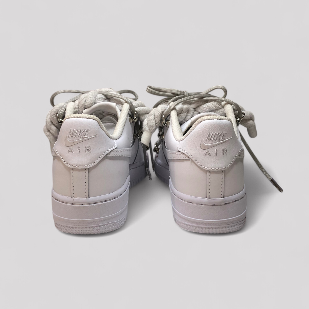 Pair of light gray Nike Air Force sneakers on a light gray background