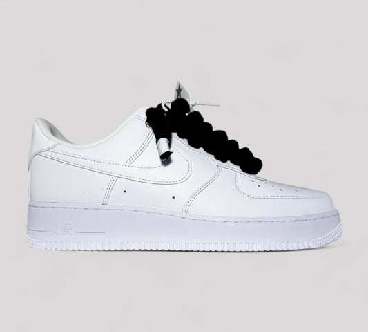 White sneaker with black rope laces from Kosmo studio on a light gray background