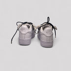 Pair of light purple Nike Air Force sneakers on a white background
