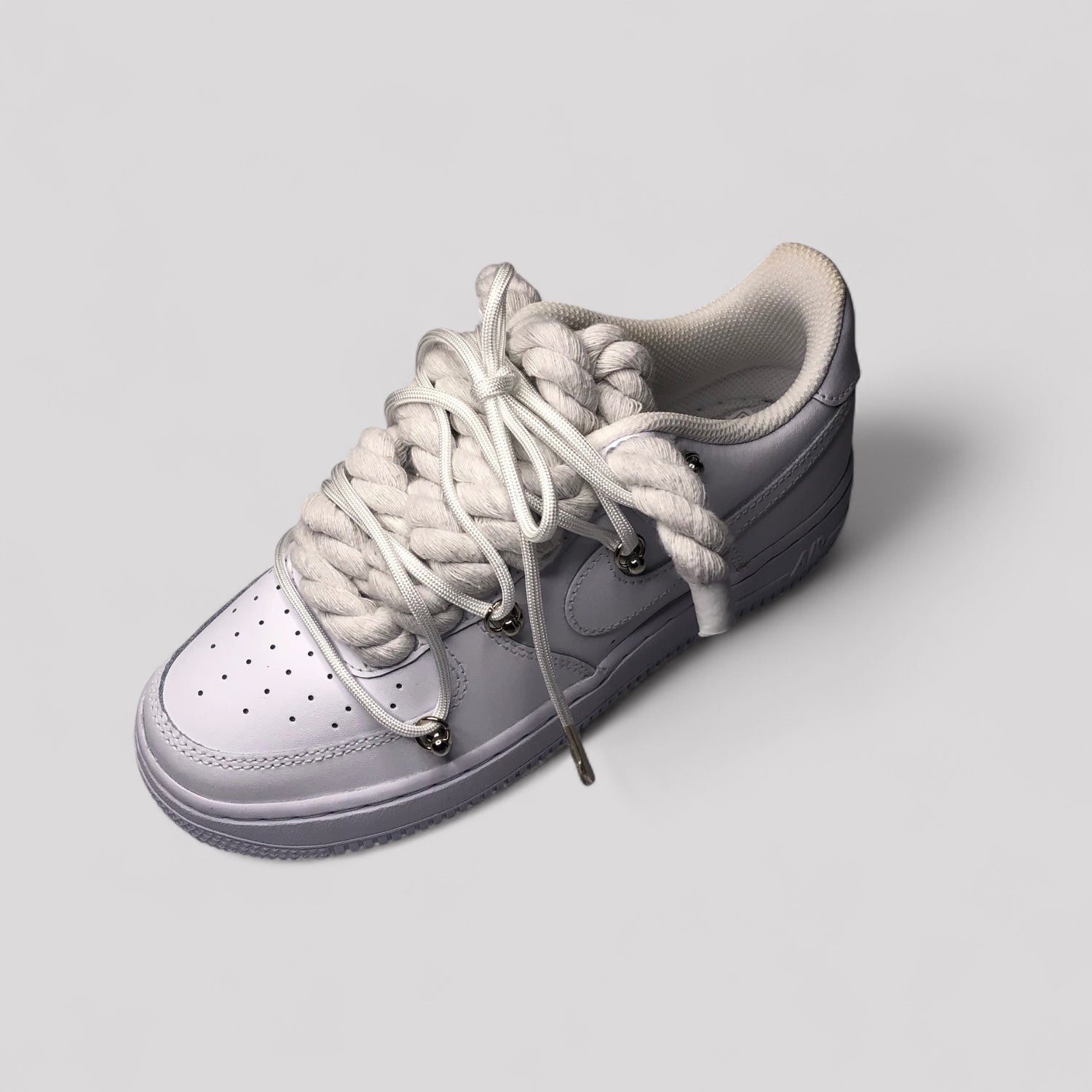 Gray sneaker with white laces on a light gray background